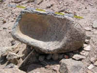 Heavily worn stone quern from UK001